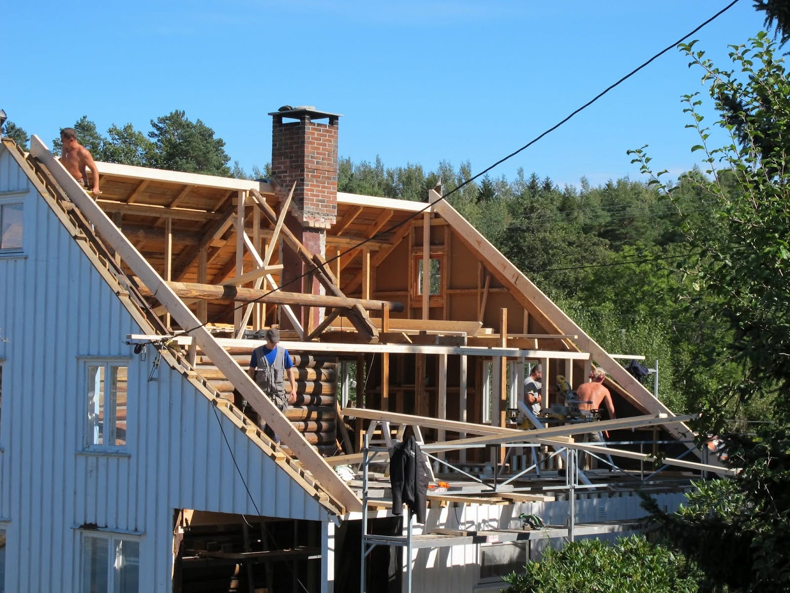 Bolig med påbygd loftsetasje og nytt reisverk under arbeid i sommersol